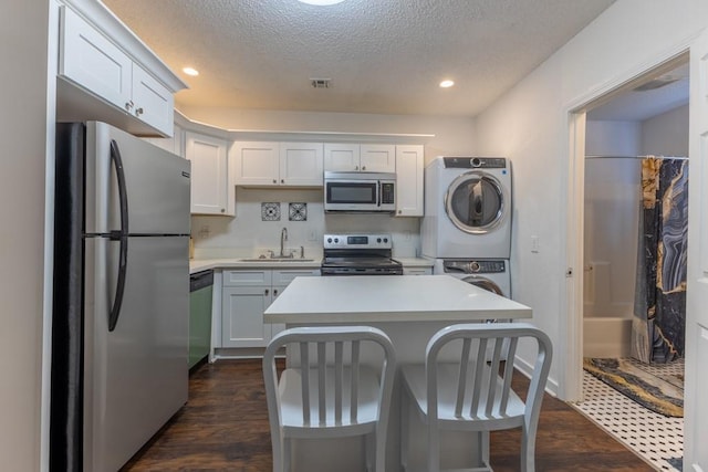 226062 N Roman St, New Orleans, LA 70117 - kitchen with a sink, visible vents, stacked washer / dryer, light countertops, and appliances with stainless steel finishes