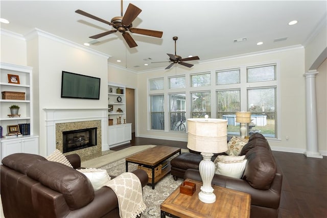 living area featuring crown molding, wood finished floors, a high end fireplace, and ornate columns