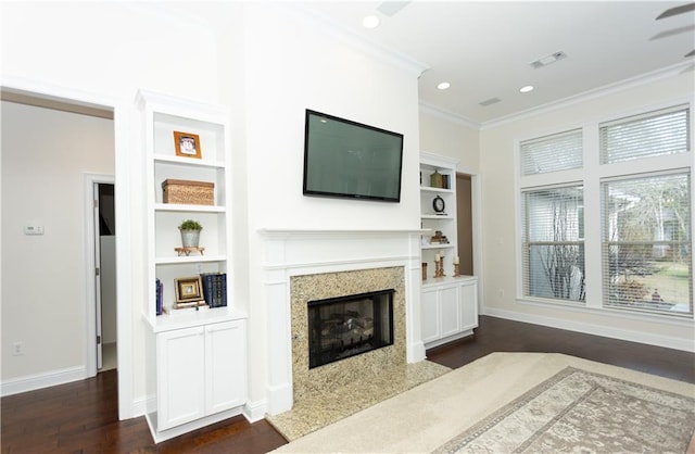 living room featuring baseboards, a premium fireplace, ornamental molding, dark wood-type flooring, and built in shelves