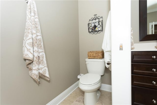 bathroom with toilet, tile patterned flooring, baseboards, and vanity