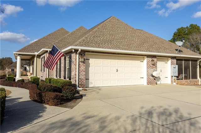 view of side of property with a garage, driveway, brick siding, and a shingled roof