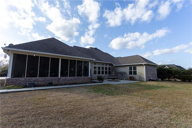 back of property featuring brick siding, a shingled roof, a sunroom, a yard, and a patio area