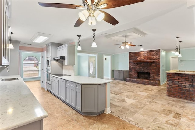 kitchen featuring a sink, stainless steel oven, hanging light fixtures, gray cabinets, and crown molding