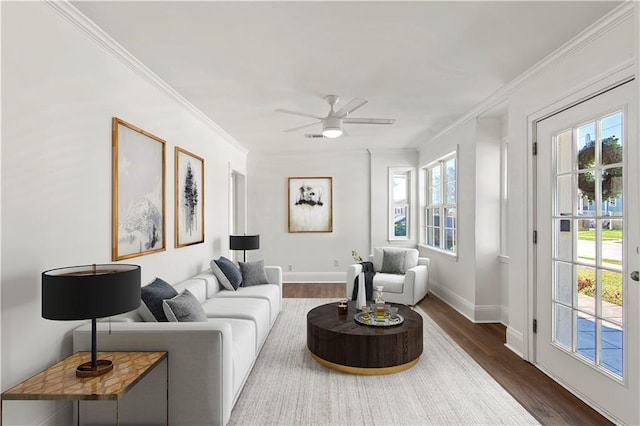 living room with a ceiling fan, baseboards, ornamental molding, and dark wood-style flooring