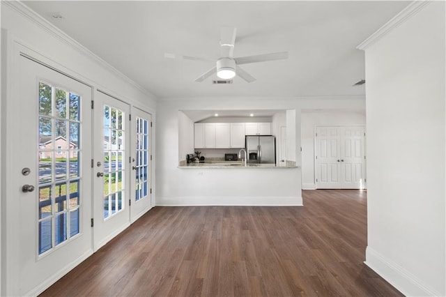 kitchen with crown molding, a peninsula, stainless steel refrigerator with ice dispenser, and white cabinets