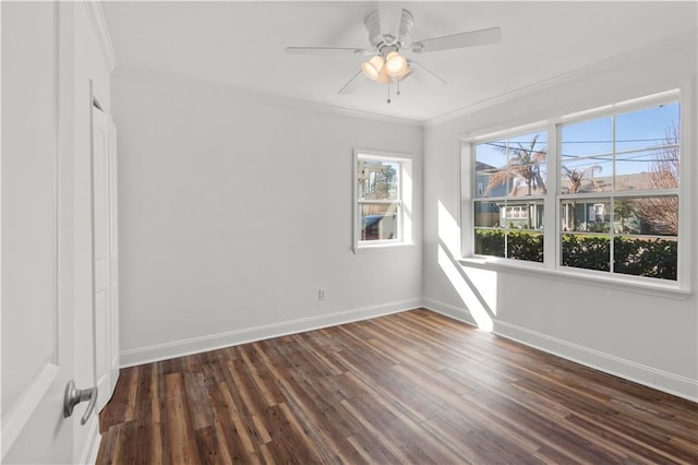 empty room with a ceiling fan, baseboards, ornamental molding, and dark wood-type flooring