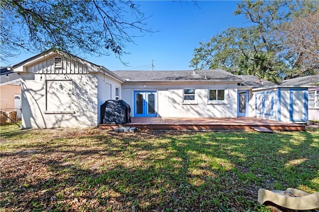 back of house with a deck and a yard