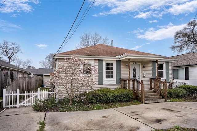 bungalow featuring fence