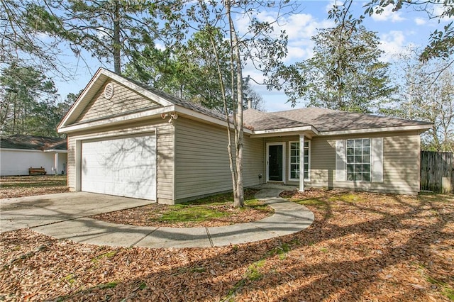 ranch-style house featuring driveway, an attached garage, and fence