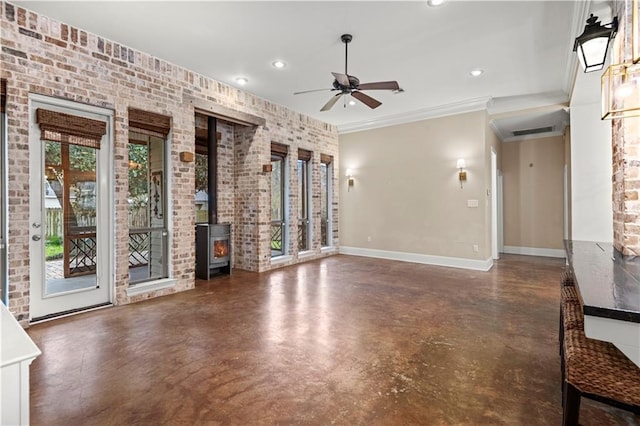 spare room featuring visible vents, concrete floors, a wood stove, and baseboards