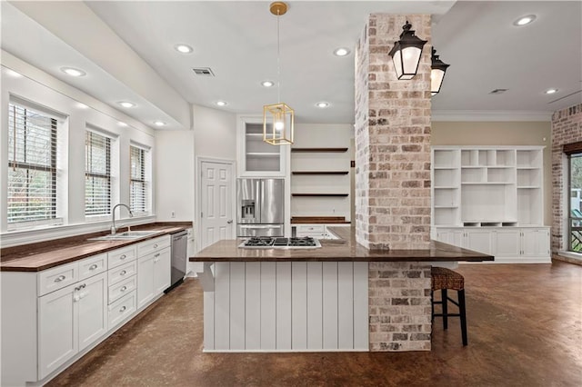 kitchen with dark countertops, appliances with stainless steel finishes, concrete flooring, open shelves, and a sink