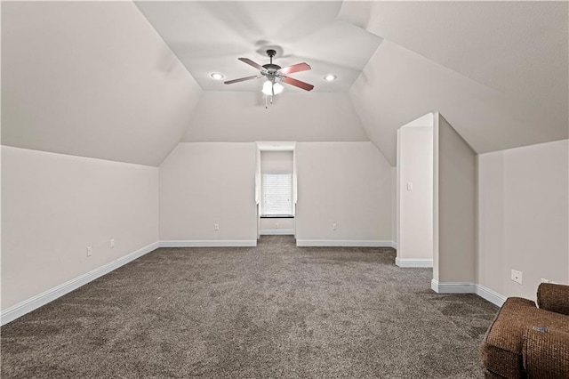 additional living space with carpet, vaulted ceiling, baseboards, and ceiling fan