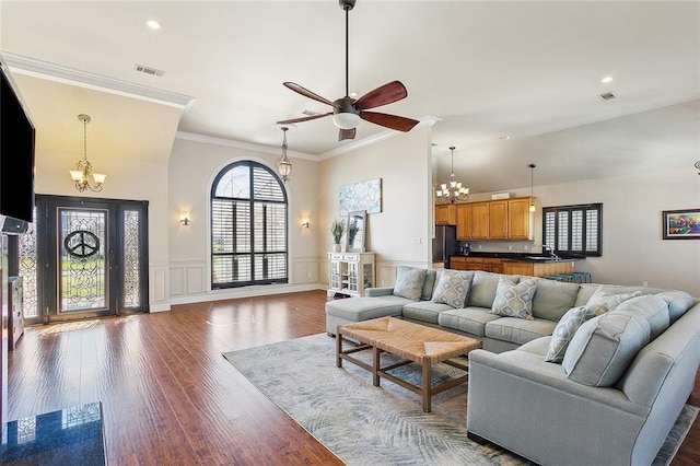 1042 Mariners Cove Blvd, Slidell, LA 70458 - living area featuring a chandelier, ceiling fan, wood finished floors, ornamental molding, and a wainscoted wall