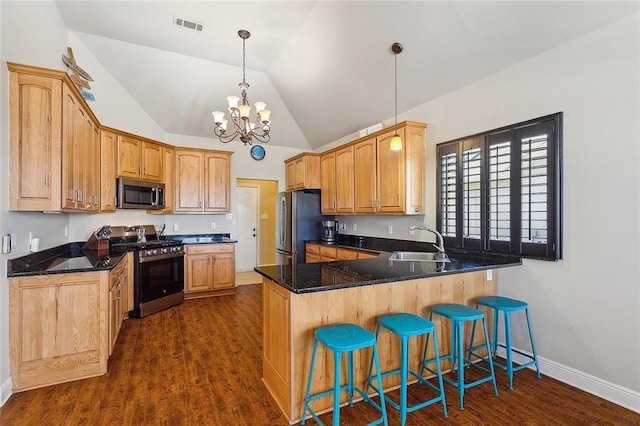 1042 Mariners Cove Blvd, Slidell, LA 70458 - kitchen with appliances with stainless steel finishes, a peninsula, a chandelier, vaulted ceiling, and a breakfast bar