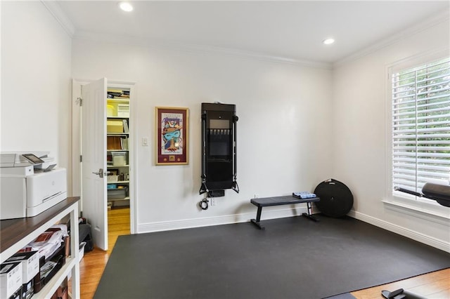 exercise area featuring recessed lighting, crown molding, baseboards, and wood finished floors