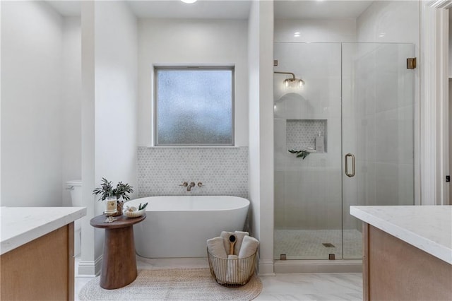 full bath with a freestanding bath, a stall shower, vanity, and tile walls