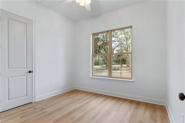 spare room featuring light wood-style floors, baseboards, and a wealth of natural light