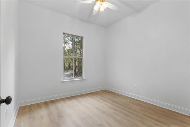 unfurnished room featuring ceiling fan, light wood-style flooring, and baseboards