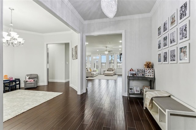 interior space featuring dark wood-style floors, crown molding, baseboards, and ceiling fan with notable chandelier