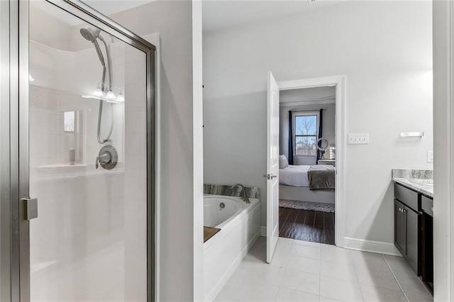 ensuite bathroom featuring ensuite bathroom, tile patterned flooring, vanity, a shower stall, and a bath