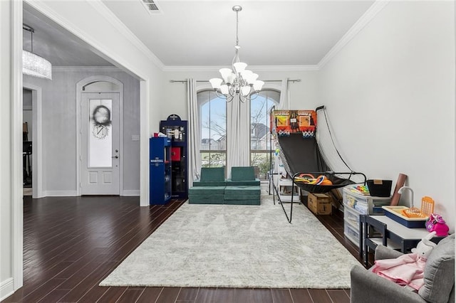 foyer featuring a healthy amount of sunlight, dark wood-type flooring, visible vents, and an inviting chandelier