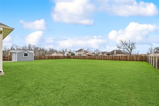 view of yard with an outbuilding, a storage unit, and a fenced backyard