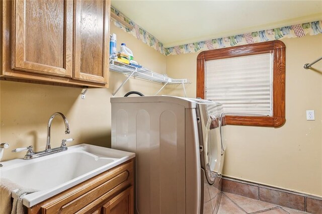 5116 Franklin Ave, New Orleans, LA 70122 - washroom featuring separate washer and dryer, cabinet space, and light tile patterned floors