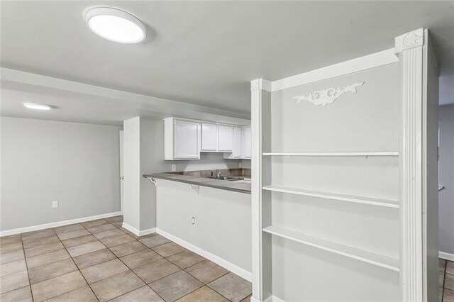 5116 Franklin Ave, New Orleans, LA 70122 - kitchen featuring white cabinets, baseboards, tile patterned floors, and dark countertops