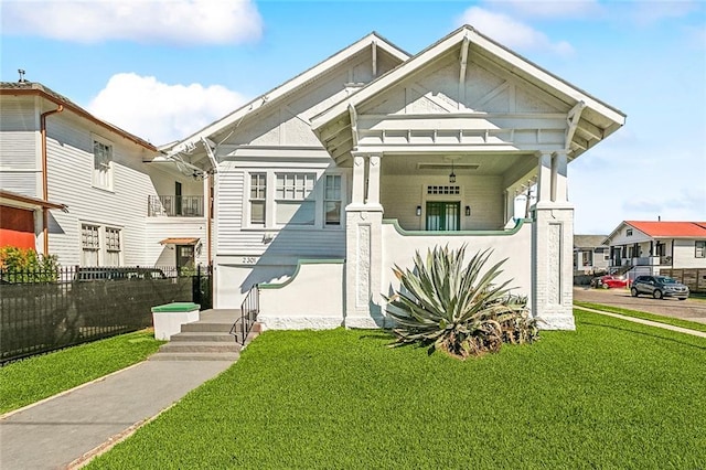 view of front of property featuring a porch, a front yard, and fence