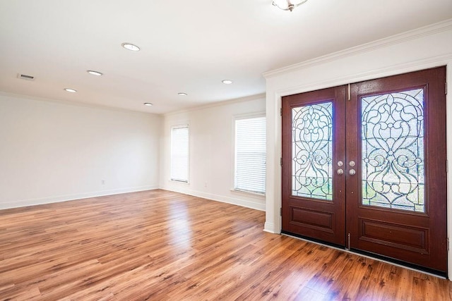 entrance foyer with light wood-style floors, visible vents, crown molding, and french doors