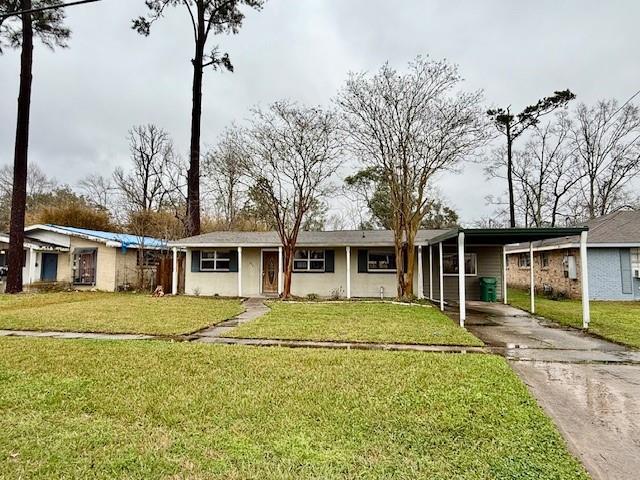 ranch-style home with a carport, a front yard, and concrete driveway