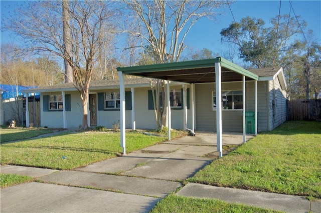 ranch-style home with an attached carport, driveway, and a front lawn