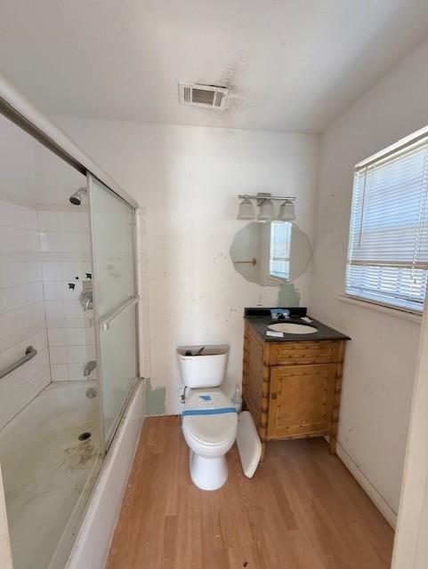 2340 Rex Pl, New Orleans, LA 70125 - bathroom with visible vents, toilet, wood finished floors, combined bath / shower with glass door, and vanity