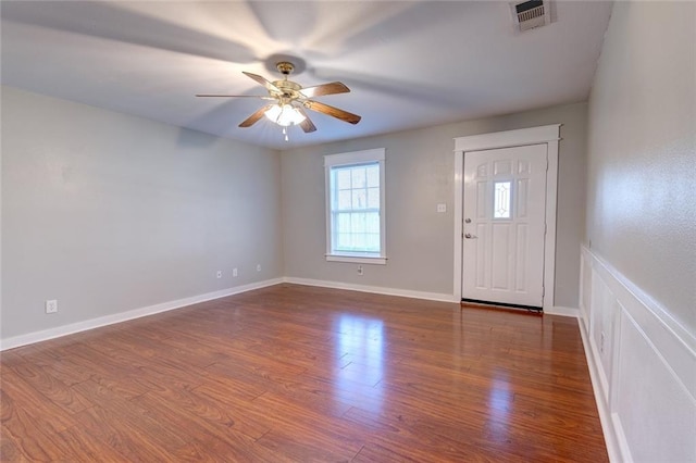 entryway with dark wood-type flooring, a ceiling fan, visible vents, and baseboards