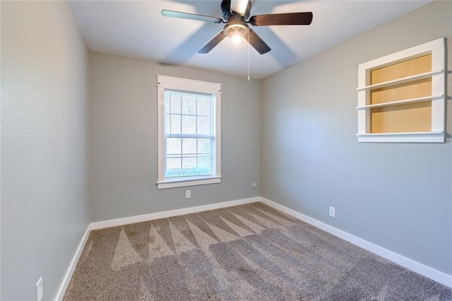 carpeted empty room with a ceiling fan and baseboards