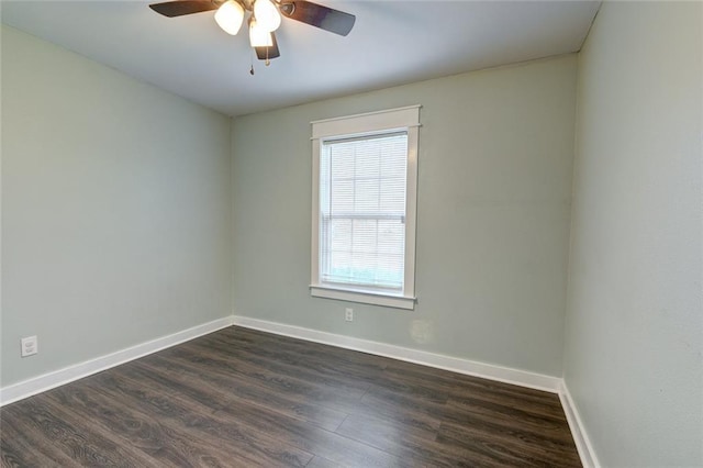 spare room with dark wood finished floors, baseboards, and ceiling fan