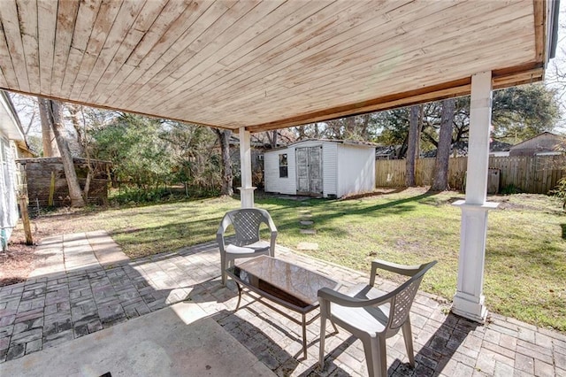 view of patio / terrace featuring a storage shed, a fenced backyard, and an outbuilding