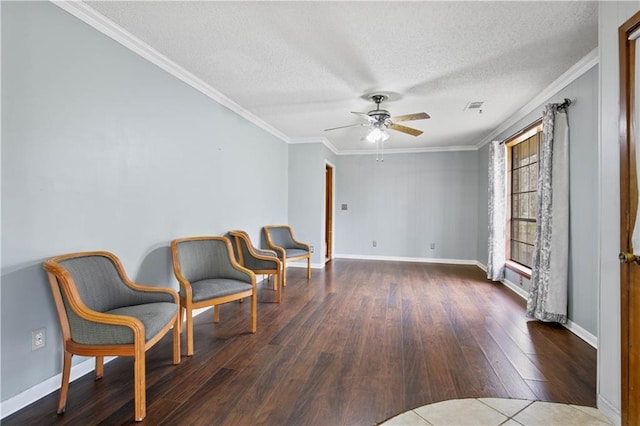 living area featuring a textured ceiling, baseboards, dark wood finished floors, and crown molding