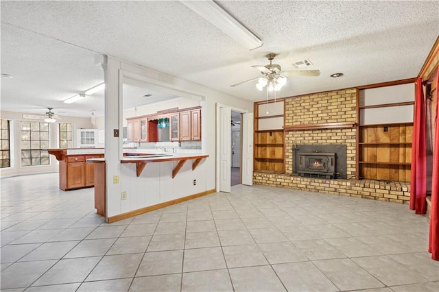 unfurnished living room featuring light tile patterned floors, ceiling fan, visible vents, and a textured ceiling