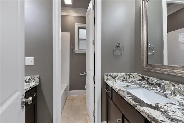 bathroom with ornamental molding,  shower combination, vanity, and baseboards