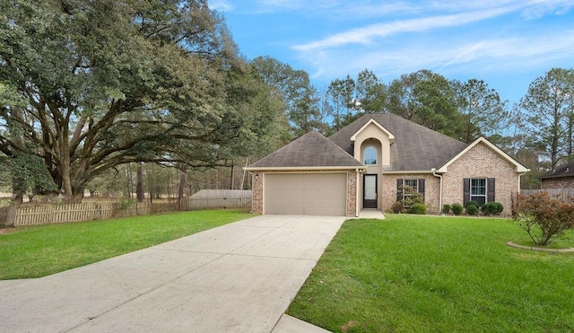 view of front of home featuring an attached garage, fence, and a front yard