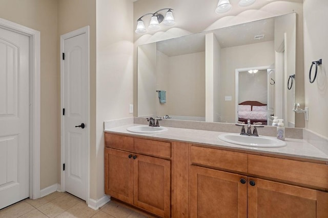 ensuite bathroom featuring double vanity, tile patterned floors, a sink, and ensuite bathroom