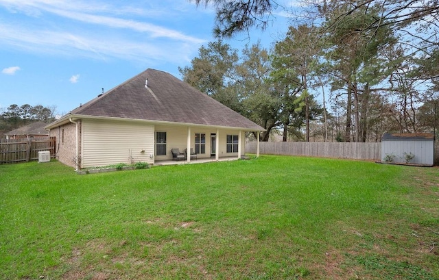 rear view of property with a fenced backyard, brick siding, an outdoor structure, a yard, and a storage unit