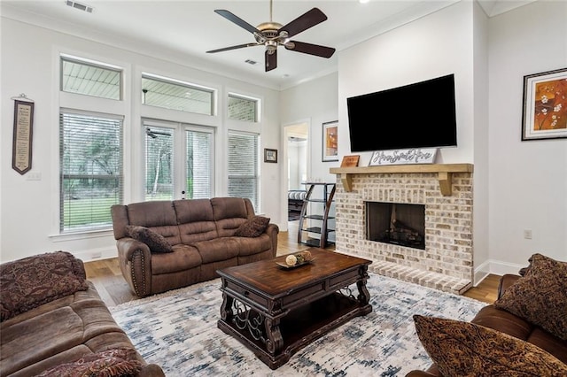 living area featuring crown molding, a fireplace, and wood finished floors