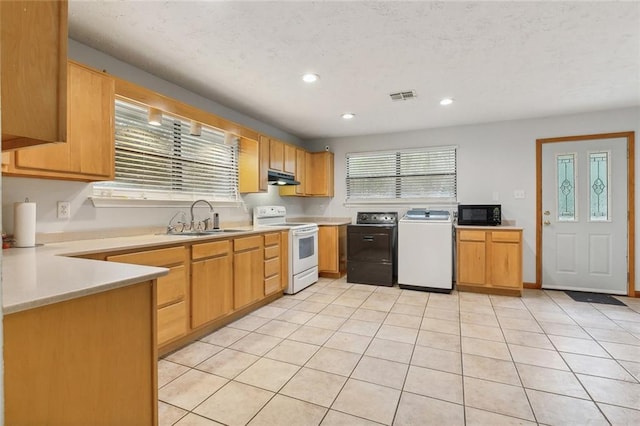 kitchen with white electric stove, black microwave, under cabinet range hood, a sink, and visible vents