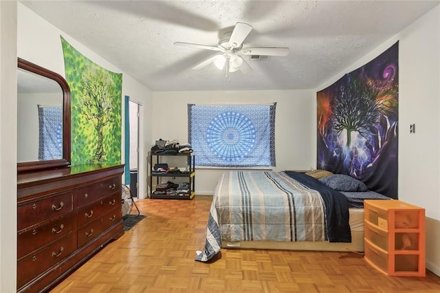 bedroom featuring a ceiling fan, visible vents, and a textured ceiling