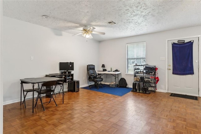 office area with ceiling fan, visible vents, baseboards, and a textured ceiling