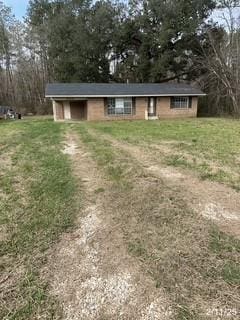 view of front of property with a front lawn and dirt driveway