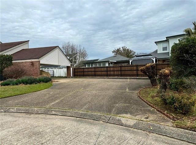 view of property exterior featuring brick siding and fence