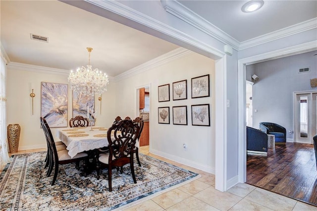 dining area featuring a notable chandelier, visible vents, crown molding, and light tile patterned flooring